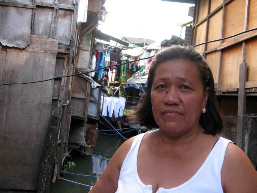 Community organizer Filomena Cinco stands amid shacks on the Estero de San Miguel, a slum neighborhood in Manila. Residents want to redevelop their neighborhood, rather than be relocated to distant suburbs under a government plan.