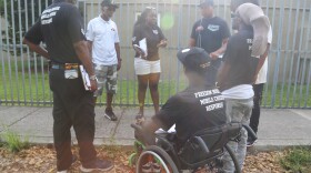 Peacemakers have a debrief before concluding their work for the day at the Lincoln Fields apartments complex in Miami, Fla. Lamont Nanton (second from left) is the group's manager and Shameka Pierce (third from left) works with the group.