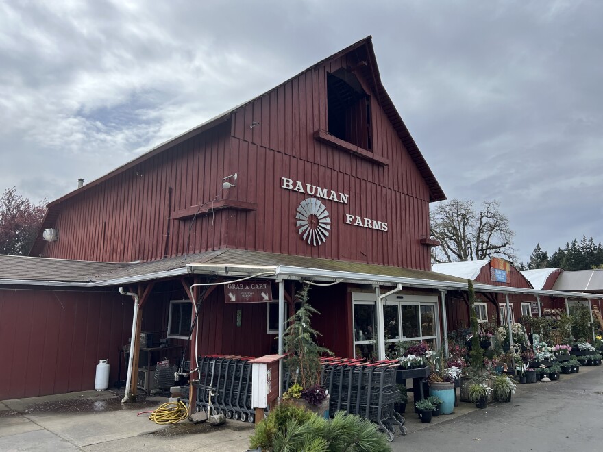 The front of a farm store. Potted plants and shopping carts are visible in the front. The building says "Bauman Farms." 