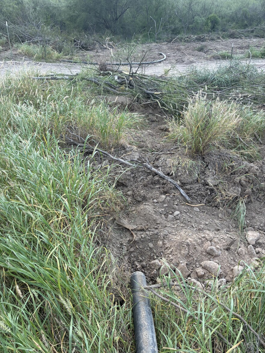 An irrigation line and cleared vegetation are visible near San Ignacio along the Rio Grande following land-clearing activity associated with a border wall project. Residents have raised questions about property rights and access related to the work.