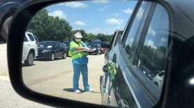 Workers at a COVID-19 test site in Norman placed patient paperwork on windshields until cars reached the front of the line. The information is then retrieved and matched up with a number on a test tube that will hold the sample taken through a nasal swab.