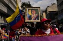 A government supporter holds an image of President Nicolas Maduro during a women's march to demand his return in Caracas, Venezuela, Tuesday, Jan. 6, 2026, three days after U.S. forces captured him and his wife. (AP Photo/Matias Delacroix)