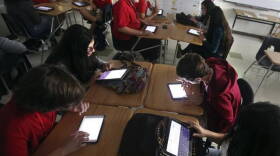 Miami Beach Senior High ninth graders work by the glow of electronic tablets in this Nov. 7, 2014, file photo. Internet is down for the second day in Miami-Dade schools, as the result of a construction accident.