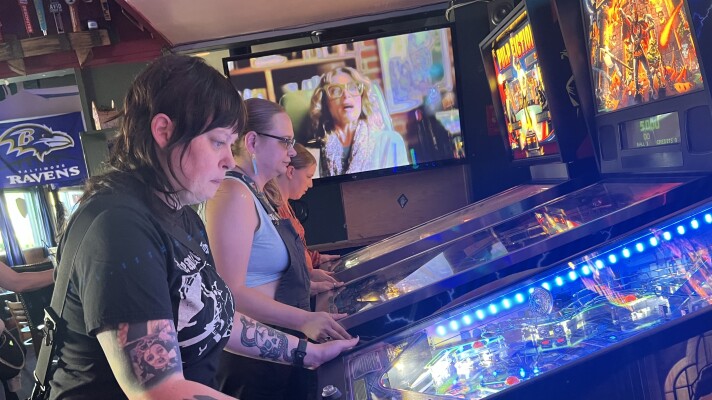 Members of Belles & Chimes Eugene playing pinball at The Flying Squirrel.