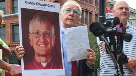 Attorney Jeff Anderson holds up a photo of retired Buffalo Auxiliary Bishop Edward Grosz and a copy of a Child Victims Lawsuit.