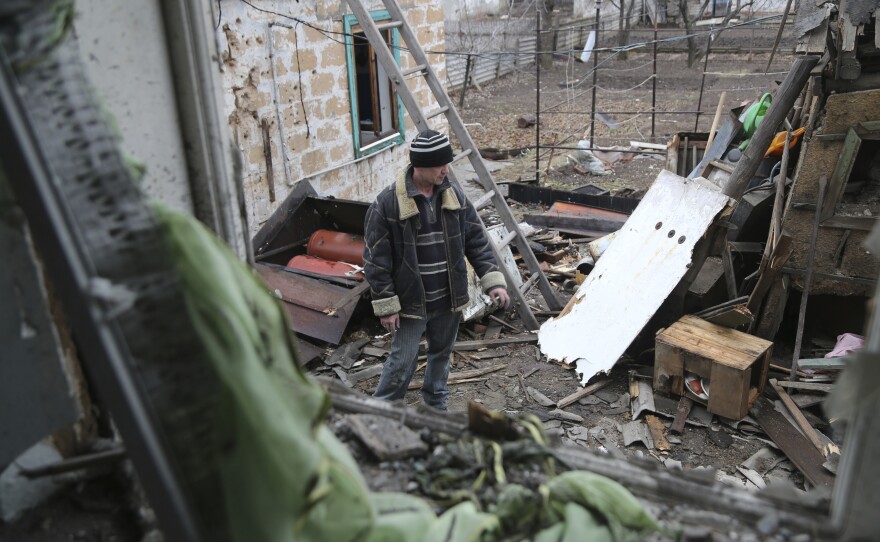 A local citizen stands between debris of his house following Ukrainian shelling in the territory controlled by pro-Russian militants, eastern Ukraine, Thursday, Feb. 24, 2022. Russian troops have launched a three-pronged assault on Ukraine that opened with air and missile strikes on Ukrainian military facilities and included ground troops invading from Crimea. (AP Photo/Alexei Alexandrov)