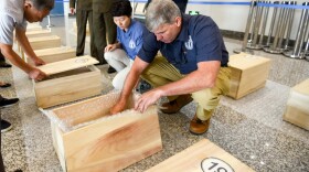 U.S. Defense Department forensic anthropologists in Wonsan, North Korea examine the contents of boxes containing the possible remains of U.S. MIAs July 27, 2018.