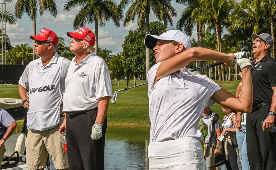 Former President Donald Trump watches his granddaughter, Kai Trump, play golf at Trump National Doral Miami golf club on October 27, 2022 in Miami, Florida.