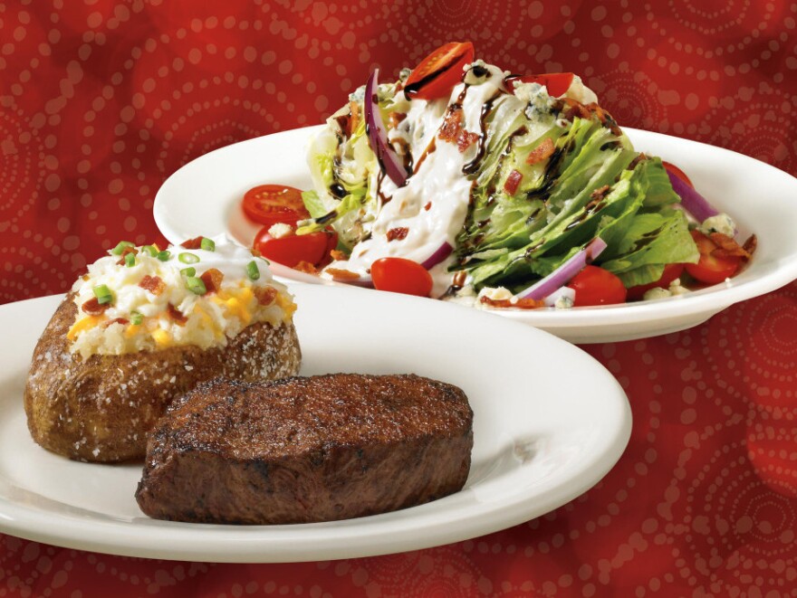 There, behind the sirloin steak and baked potato, is Outback Steakhouse's calorie-rich blue cheese wedge salad.