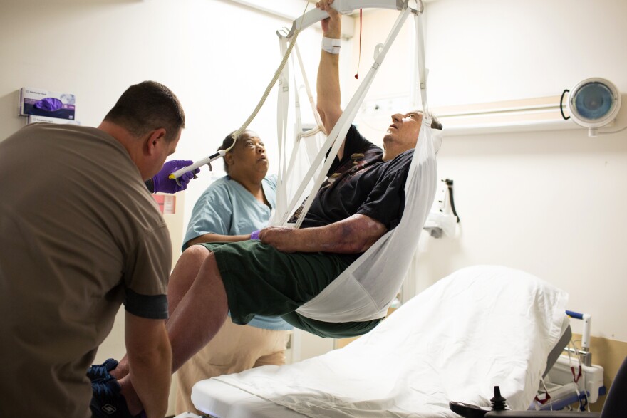 Michael Bolla and Sally Singer lift Leon Anders using a ceiling lift and sling at the VA Hospital in Loma Linda, Calif. The VA system is among a very small number of hospitals that have installed equipment and provided proper training so their nursing staff can avoid physically lifting and moving patients themselves.