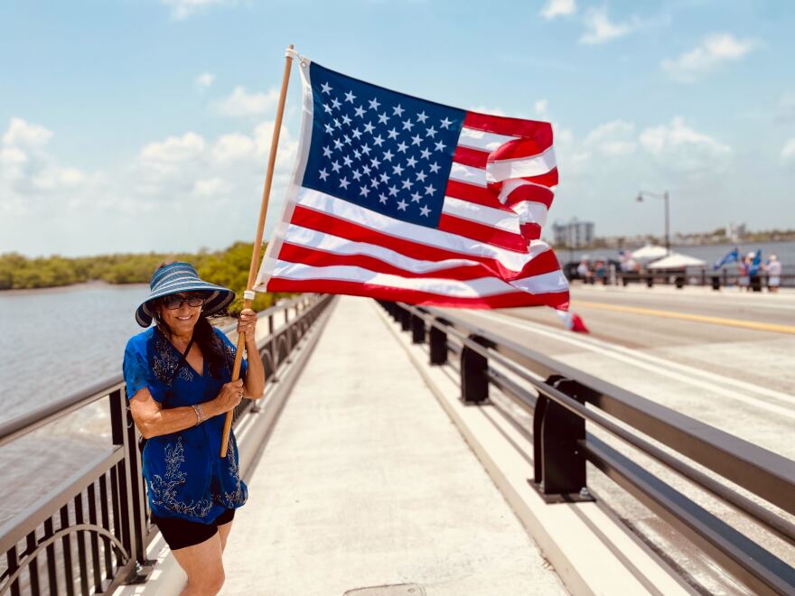 Adriane Shochet, a Trump loyalist, holds an American flag during a protest near Mar-a-lago.jpg