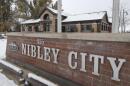 A brick sign in front of a brick office building, the words "Nibley City" are present on the sign.