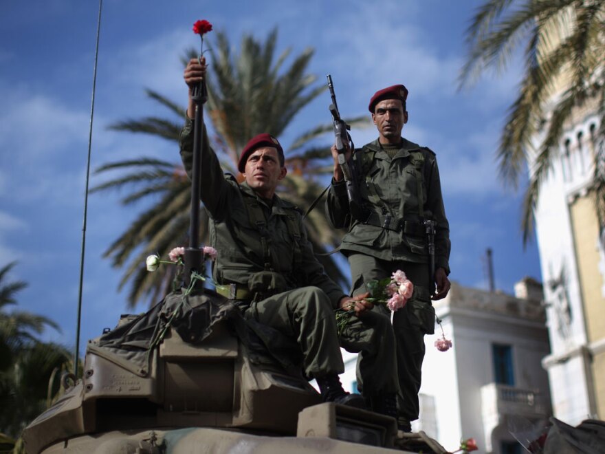A Tunisian soldier arranges flowers on his tank on Jan. 21 in Tunis.