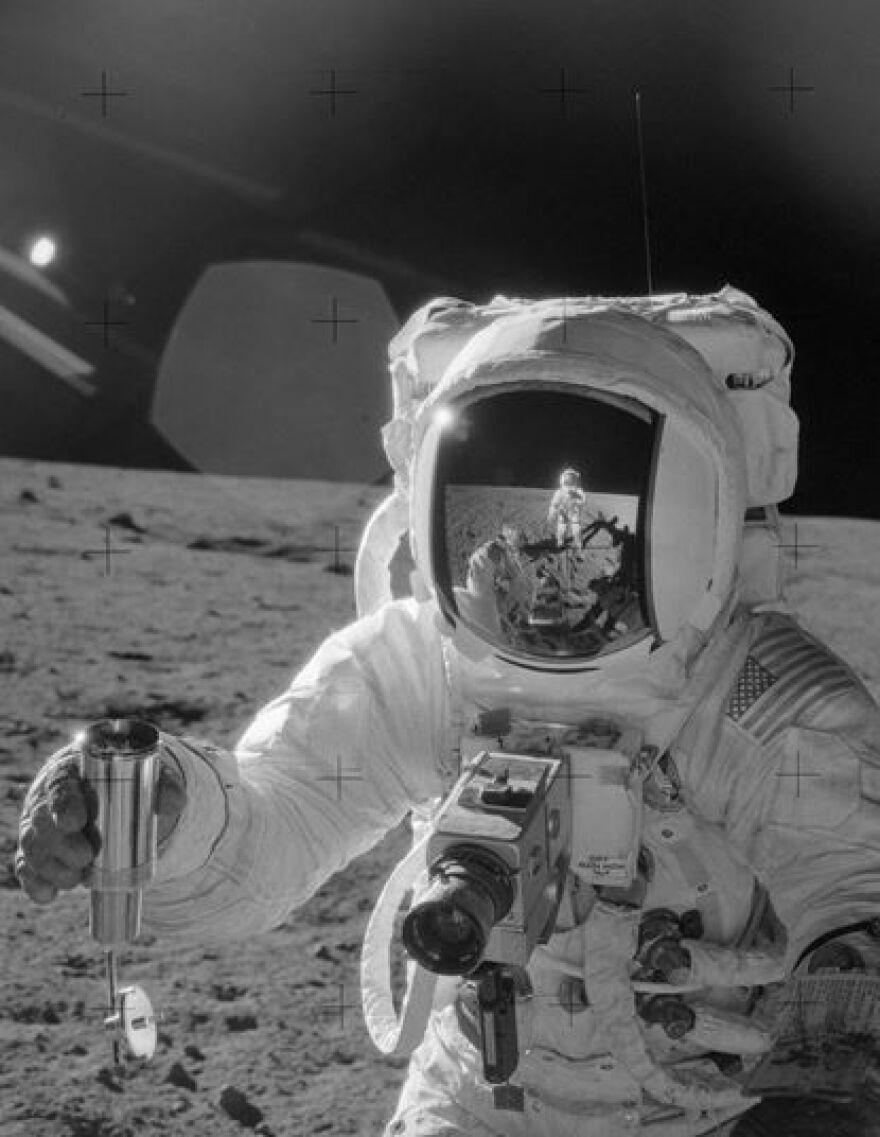 Apollo 12 astronaut Alan Bean collects samples on lunar surface.