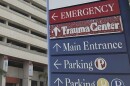 A sign that points to the emergency room, trauma center, main entrance, and parking at a Miami hospital. 