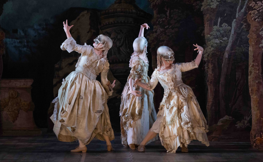 The ghosts are dressed in gray gowns with skull masks, and they dance around the stage in bare feet.