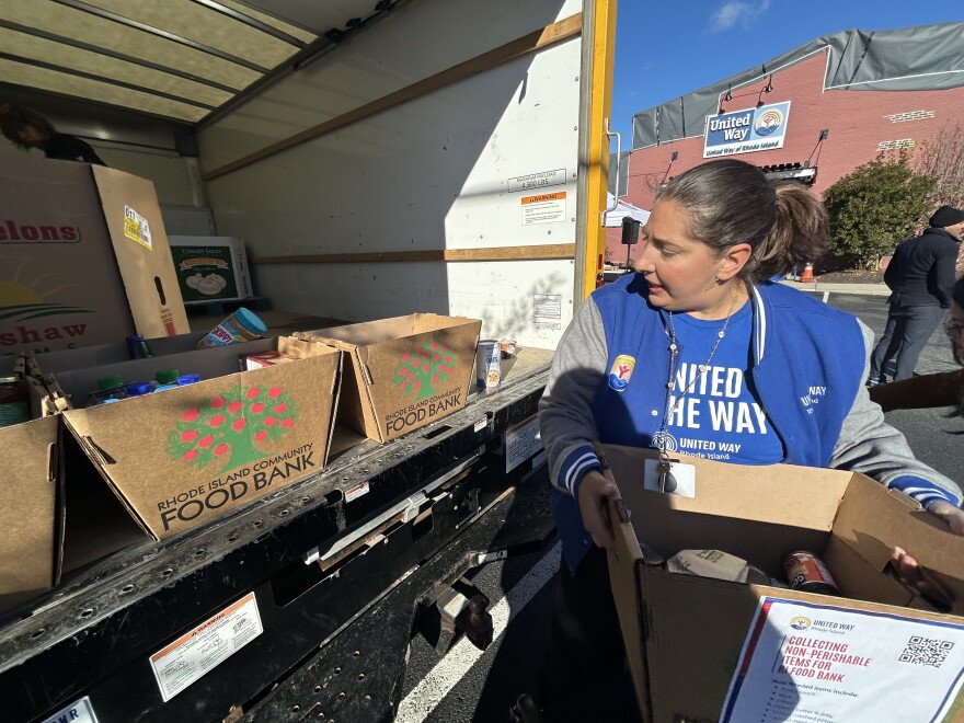 A staff member from the United Way in Rhode Island collects food for a food drive in Providence, Rhode Island.