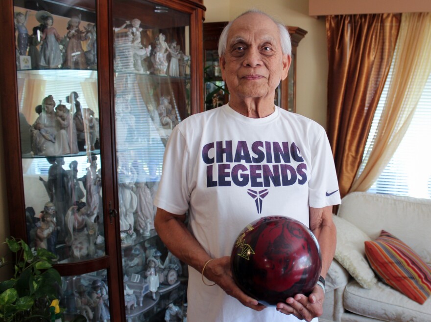 Alex Padua, who was an avid bowler at Naval Support Activity Bethesda, poses with his bowling ball at his home in Wheaton, Md.
