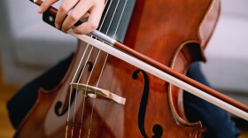 Young boy practicing cello indoors