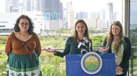Florida Commissioner of Agriculture and Consumer Services Nikki Fried, center, speaks during a news conference along with youth climate leaders, Valholly Frank, left, and Delaney Reynolds, right, Thursday, April 21, 2022, at the Phillip & Patricia Frost Museum of Science in Miami. Fried unveil a proposed rule to require that utilities operating in the state generate 100% of their electricity from renewable sources of energy by 2050.