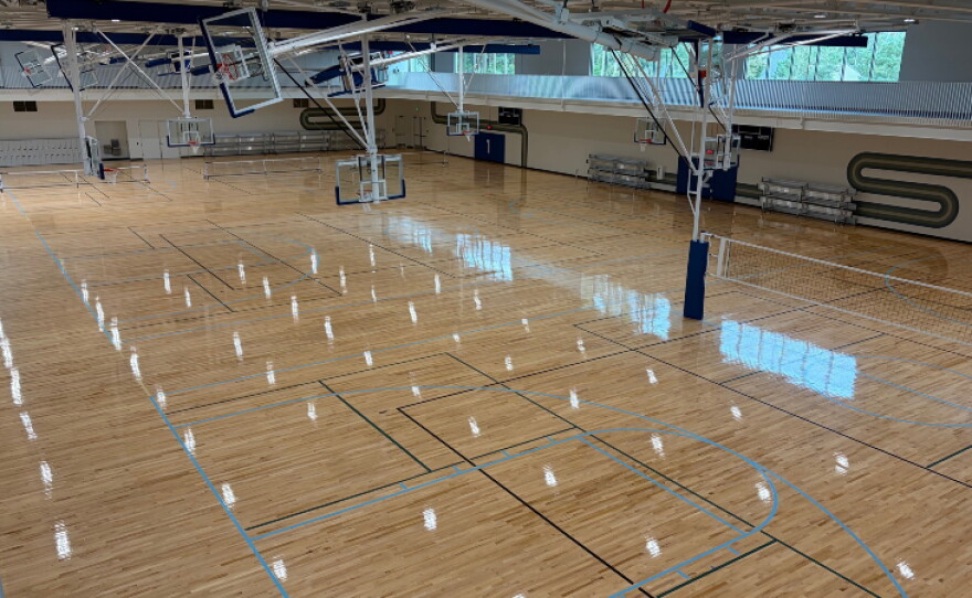 Amenities include three basketball courts, a one-mile indoor walking track, snack bar, fitness center, multi-sport simulator, playground, rentable event space, and child watch center.