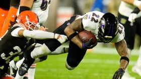 Baltimore Ravens running back Derrick Henry (22) is stopped by Cleveland Browns safety Ronnie Hickman (33) in the first half of an NFL football game in Cleveland, Sunday, Nov. 16, 2025. (AP Photo/Sue Ogrocki)