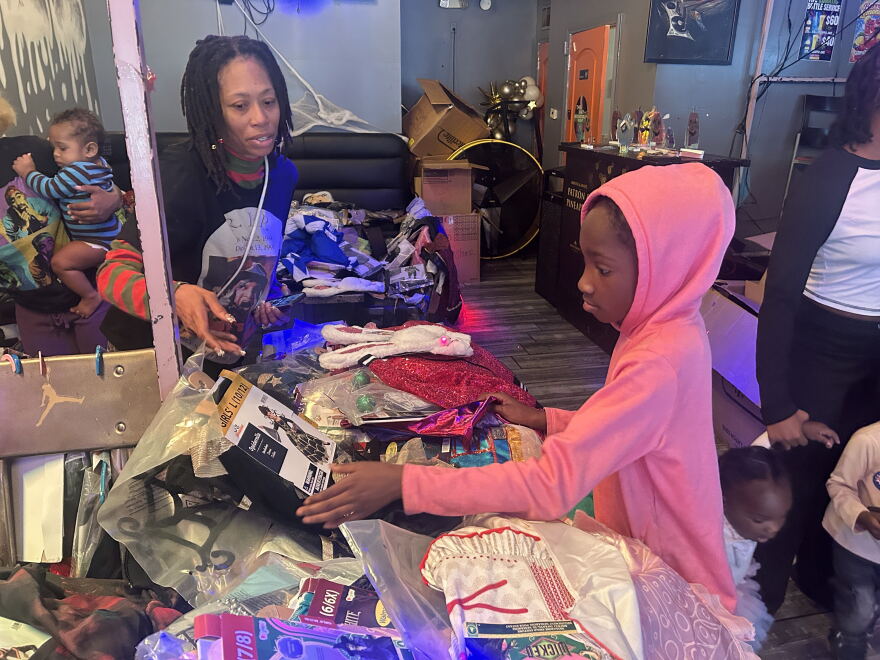 A young girl in a pink hoodie looking at a selection of costumes 