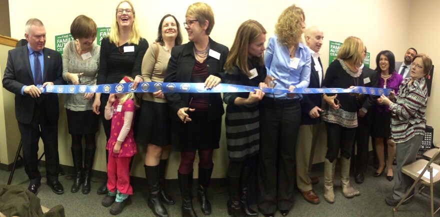 Community leaders and members of the organization prepare for the ribbon cutting