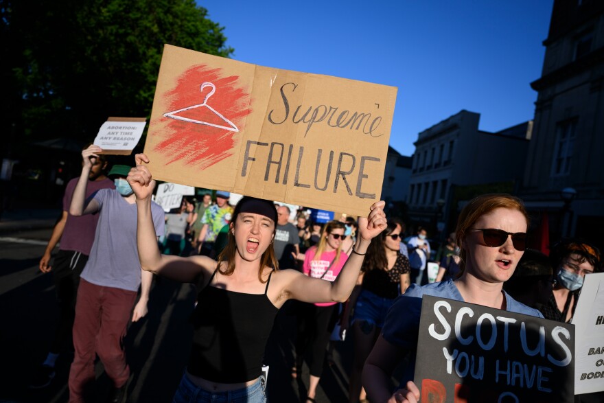 Mairead Koehler holds a sign decrying the Supreme Court’s decision to overturn Roe v. Way as hundreds of protesters march through the streets of downtown New Haven.