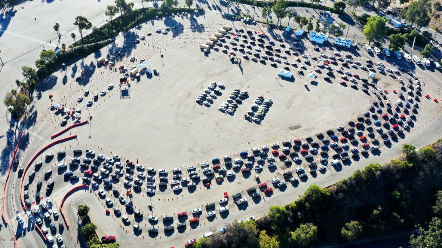 Cars are lined up at Dodger Stadium in Los Angeles for coronavirus testing. Nearly 2 million people are getting tested a day in the U.S. A new analysis shows millions more are needed to protect the most vulnerable.