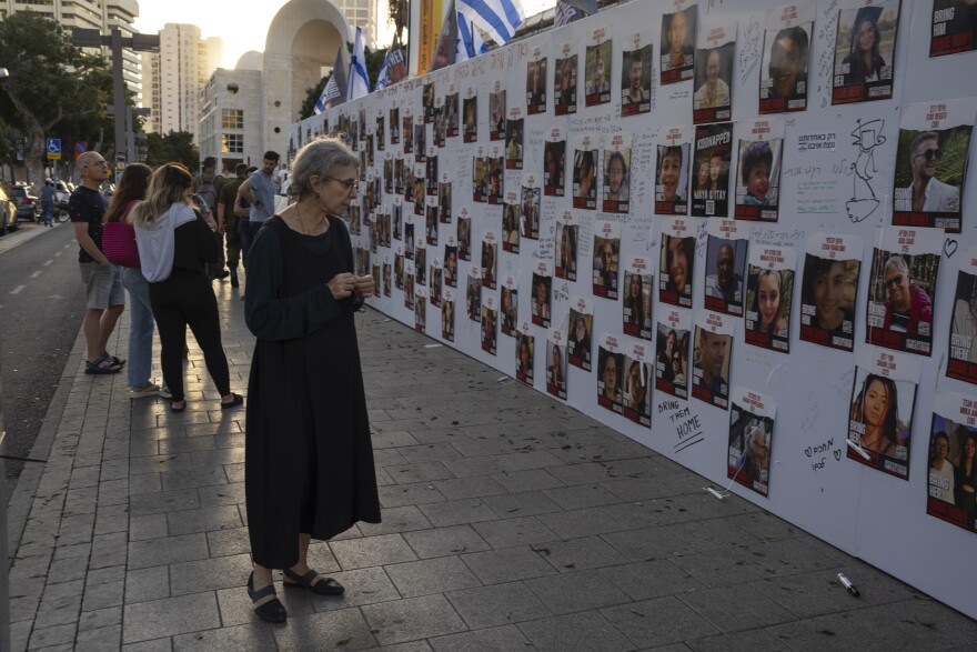 Fri., Oct. 20: An Israeli woman looks at photos of missing Israelis missing held captive in Gaza, displayed on a wall in Tel Aviv.