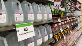 Gallons of drinking water sits on shelves. 