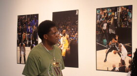 A Tubman Gallery visitor admires a collection of work by Coyia Malone. Malone was a sideline photographer during the 2026 NBA Finals.