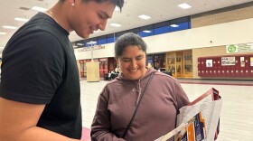A mother and son look at papers together at a resource fair