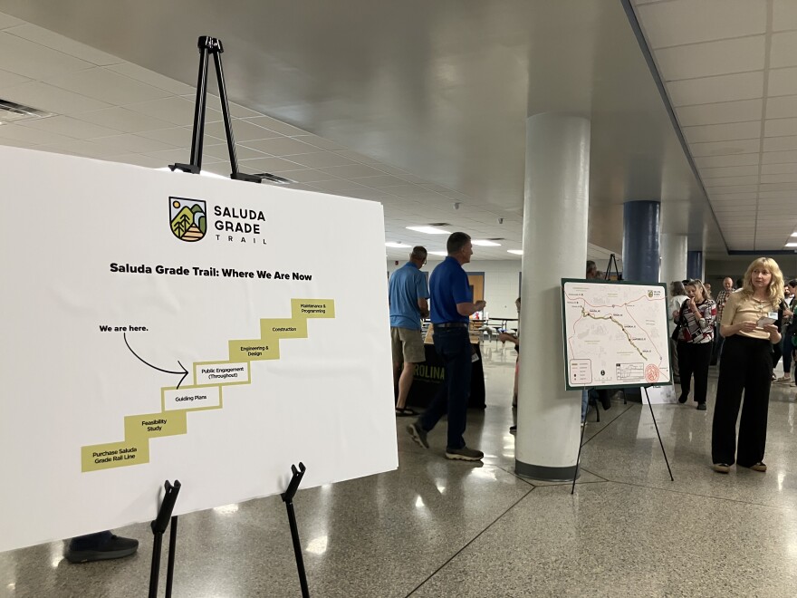 Participants examine posterboards at a forum on the Saluda Grade Trail Thursday, April 23, 2026.