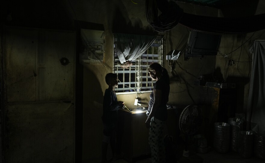 Jhonkeiber Romero, one of five children who returned to Venezuela from Mexico with their parents after abandoning plans to reach the United States amid President Donald Trump's migration crackdown, talks to his grandmother at their home in Maracaibo, Venezuela, Monday, June 16, 2025. (AP Photo/Matias Delacroix)