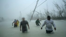 Volunteers walk under the wind and rain of Hurricane Dorian, on a flooded road after rescuing several families that arrived on small boats, near the Causarina bridge in Freeport, Grand Bahama, Bahamas, Tuesday, Sept. 3, 2019. The storm’s punishing winds and muddy brown floodwaters devastated thousands of homes, crippled hospitals and trapped people in attics. (AP Photo/Ramon Espinosa)