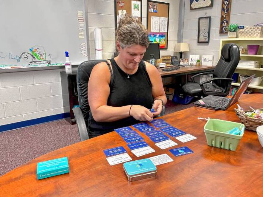 Beth Corkum, coordinator of wellness and equity of SAU 67, uses the wellness cards at her office in Bow High School. SRUTHI GOPALAKRISHNAN / Monitor staff