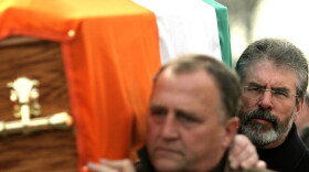 Sinn Fein President Gerry Adams, right, carries the coffin of senior IRA commander Brendan Hughes, in West Belfast, Northern Ireland.
