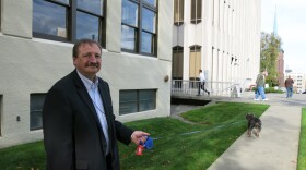 Dave Somers walks Hewitt the dog outside the existing county courthouse.