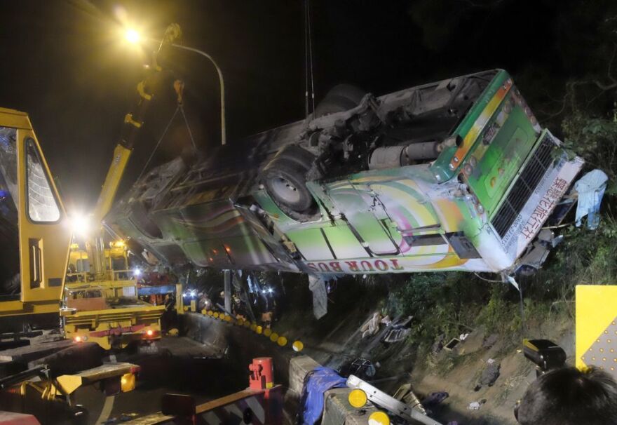 A bus that crashed along a highway is lifted by a crane on Tuesday in Taipei, Taiwan.