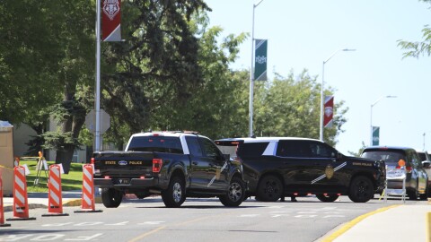 Authorities block access to an area on the University of New Mexico campus where two people were shot, one fatally, in the early morning hours in Albuquerque, N.M., on Friday, July 25, 2025. (AP Photo/Susan Montoya Bryan)