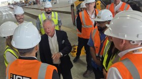 Lord Anthony Bamford, the chair of JCB, is surrounded by employees during a tour of its future San Antonio plant site on March 30, 2026
