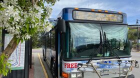 A regional transit bus is shown idling along a city street.