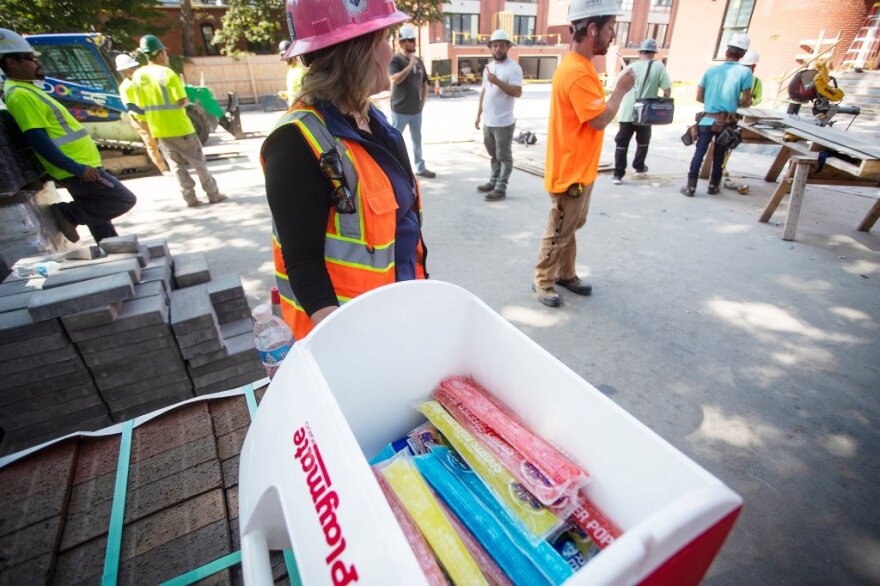 Workers take a break and eat freeze pops at a construction site in Portland’s West End where they are building luxury townhomes.