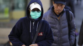 A masked woman walks a street in the Chinatown district of San Francisco on Friday, Jan. 31, 2020. As China grapples with the growing coronavirus outbreak, Chinese people in California are encountering a cultural disconnect as they brace for a possible spread of the virus in their adopted homeland. (AP Photo/Ben Margot)