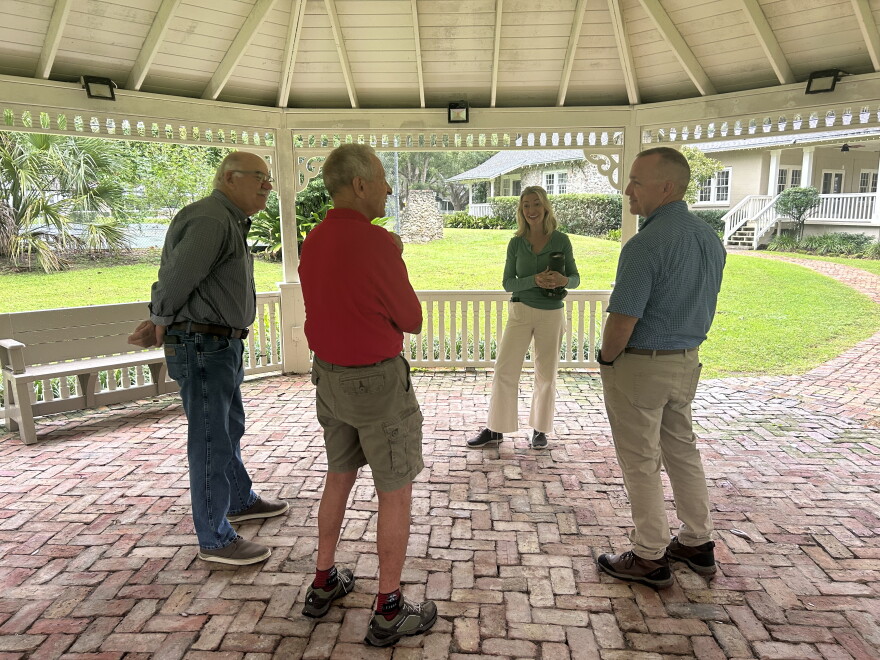 Barbara Hooper, who helped organize the festival, discusses Saturday's logistics with three members of Pasture Prime Bluegrass: Mike Matz (left), Will Harding (middle) and Brian Young (right).