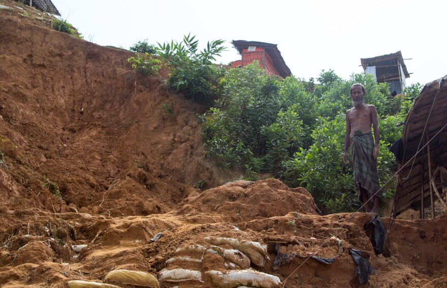 Rohingya refugee Shah Miya stands where part of his shelter used to be before it was destroyed in a landslide.