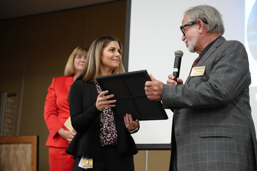 Laurel Blackburn receives an award from School Board Chair Armor Persons as Superintendent Denise Carlin looks on.