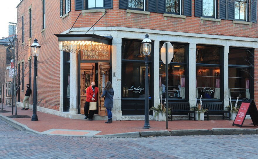 A waiter hands off takeout to a customer at Lindey's in German Village.